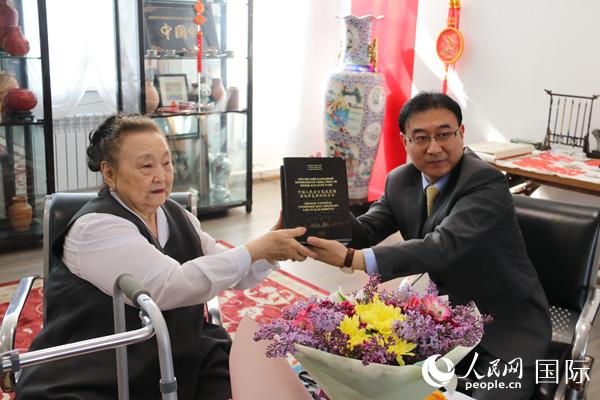 作者卡拉姆卡斯与中国驻阿拉木图总领事张伟共同展示新书（本报记者周翰博摄）